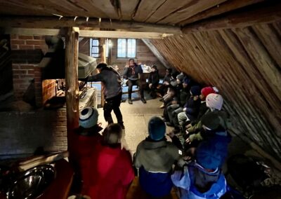 Kinder in einer Hütte vor einem Lagerfeuer.