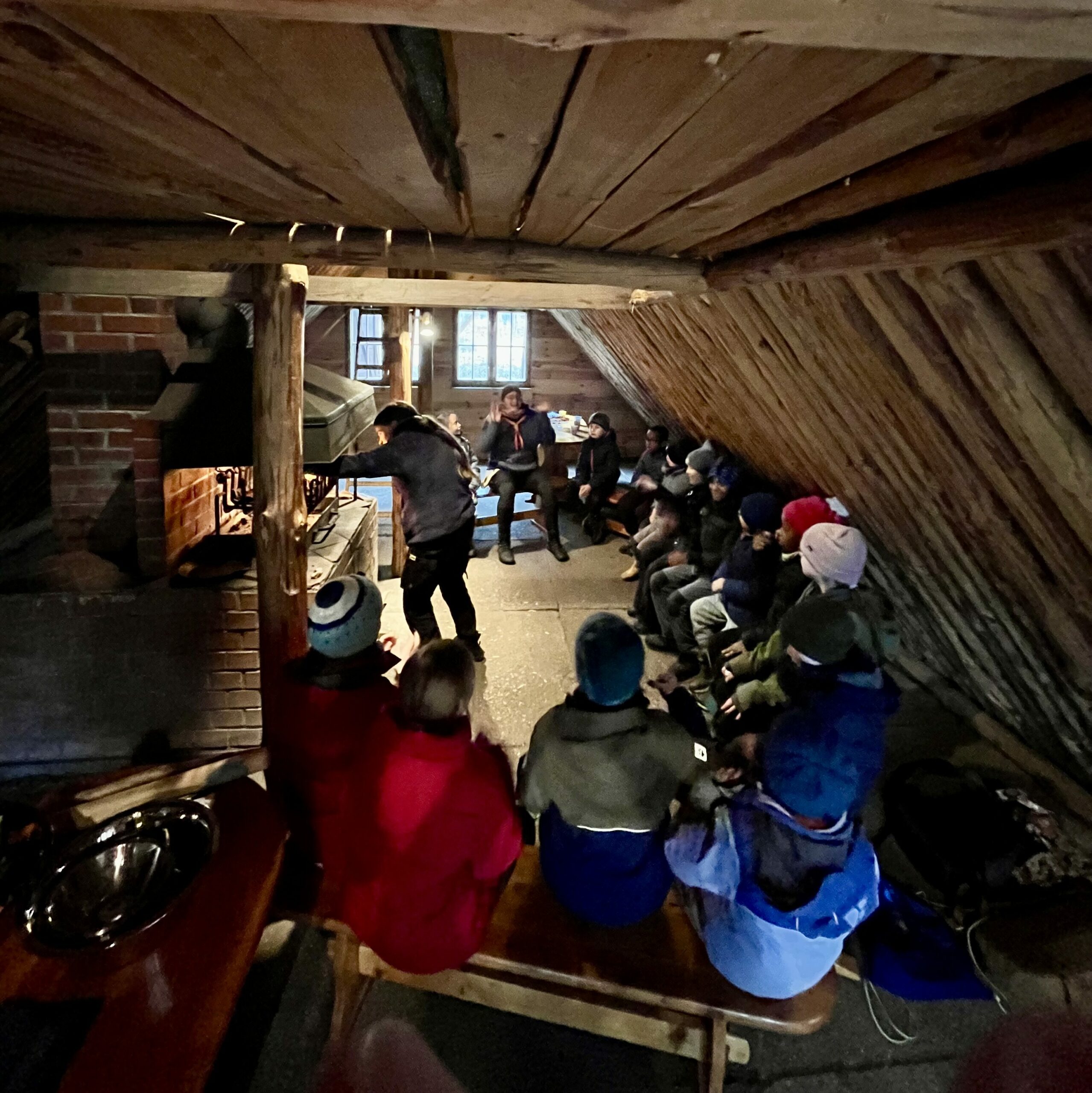 Kinder in einer Hütte vor einem Lagerfeuer.